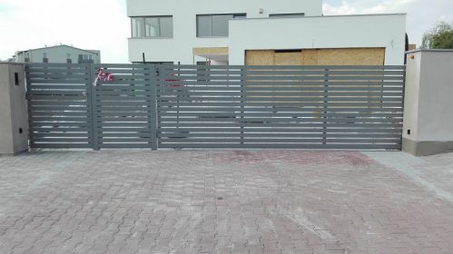 pojezdová brána po kolejnici s vodorovnou výplní před rámem z profilu 80x20 mm, barva RAL 9007