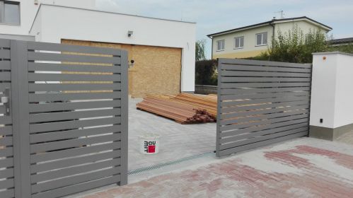 pojezdová brána po kolejnici s vodorovnou výplní před rámem z profilu 80x20 mm, barva RAL 9007